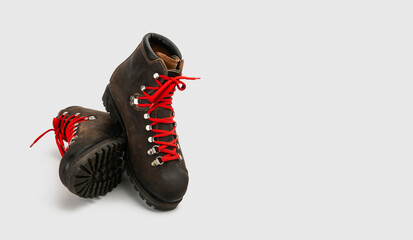 A pair of vintage rugged heavy hiking boots with red laces isolated on white background