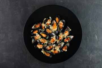Very Delicious mussels in a creamy garlic sauce. Shellfish on a stone dark table, top view, macro