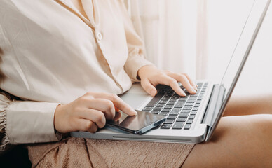 businesswoman hand using smart phone, tablet payments and holding credit card online shopping, omni channel, digital tablet docking keyboard computer at office in sun light