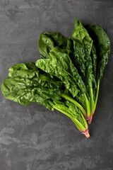 Fresh bunch of organic spinach on a dark background