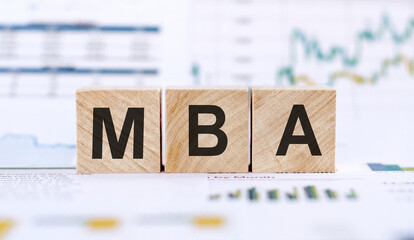 MBA - Master of Business Administration. Wooden letters spelling. MBA writting on wooden cubes on financial documents background