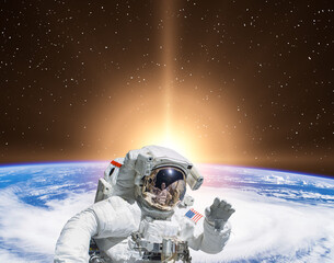 Planet earth and fascinating sunrise. Astronaut on backdrop. The elements of this image furnished by NASA.