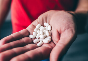 Man's hand holding sugar coated white sweets on hand. Tasty delicious yummy snack. Close up...