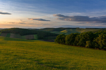 Beautiful light over green hills and beautiful blue sky with clouds