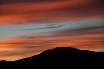 Puesta de sol de naranja intenso sobre montañas 