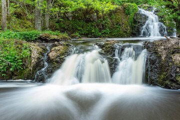 Stunning Slow falling Water Hallamolla Waterfall in lush rural Forest during springtime in Skane Osterlen near national park Stenshuvud, South Sweden.  Long Exposure Waterfall.