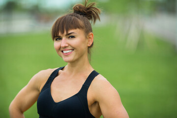 beautiful adult woman in sportswear in the summer in the park