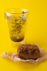 Fashion food photography: dietary russian medovik on craft paper and transparent glass of buckwheat tea