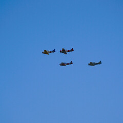Old war time planes flying in formation.