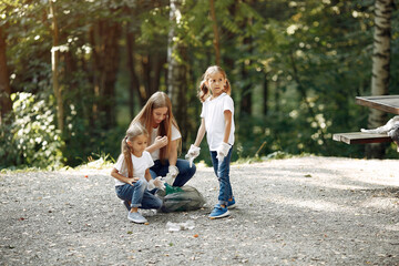Fototapeta premium Volunteers collects rubbish. Children in a park. Kids in a white t-shirts