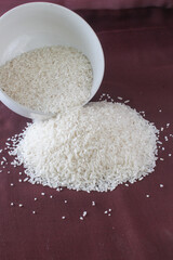 Raw white rice in bowl, and brown background
