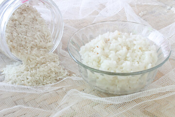 white rice and raw white rice in bowl, on croton and winnowing tray background