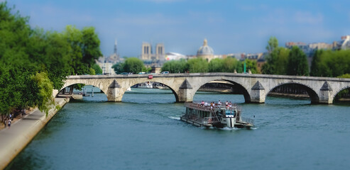 Tilt Shift Photography Pleasure boat on the Seine river in Paris against the background of an...