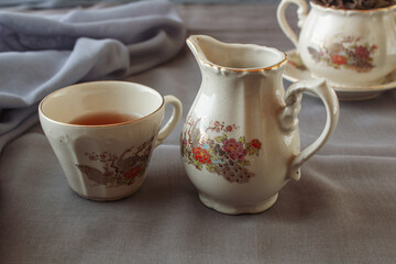 cup of tea and teapot on gray background. antique cup and teapot