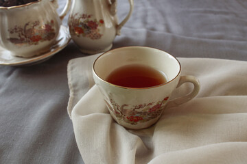 cup of tea and teapot on gray background. antique cup and teapot