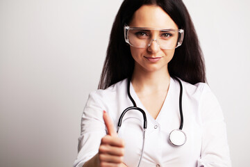 Portrait of a doctor with glasses and a white medical gown looking at the camera