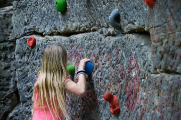 Child Girl having fun during rock climbing training on boulder wall