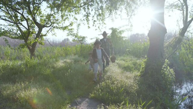 amily vacation, small cheerful children with their caring grandmother and grandfather have fun outdoors among the trees on a warm sunny day while relaxing in nature
