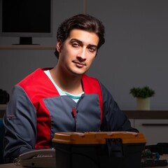Young handsome repairman repairing computer