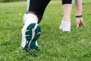 Fototapeta premium Start. Female legs close-up before jogging. Rear view