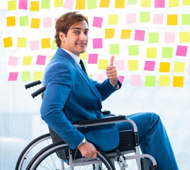 Young handsome man in wheelchair with many conflicting prioritie