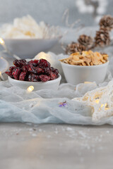 Ingredients for preparing healthy organic energy balls. Dried cranberries, sliced almonds, coconut shavings on christmas table.