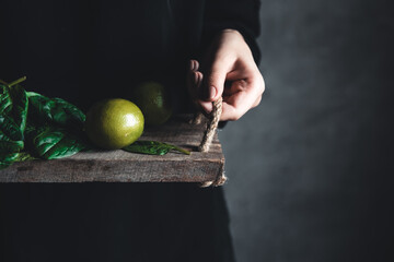 Girl holds on a vintage tray a spinach with lime. Vegan, wholesome food, eco.