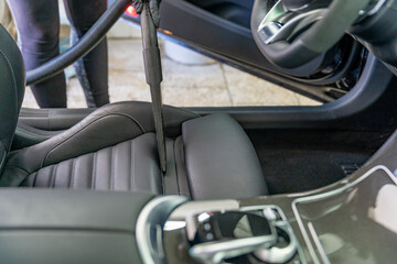 vacuuming the interior of a luxury car in the garage