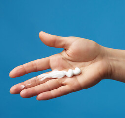 on a female palm a strip of white thick moisturizer
