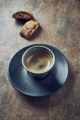 Cup of coffee with cantuccini (Italian biscuits) on rustic stone background.  