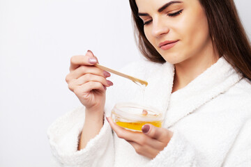 Young woman uses liquid wax to remove hair