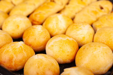 round hot baked buns with a golden crust on a baking sheet close-up, bakery products