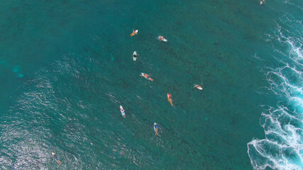 TOP DOWN: Group of friends on surfing trip in Maldives paddle out to the line up