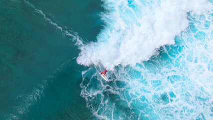 TOP DOWN: Flying above a tourist surfing a tube wave at a perfect surfing spot