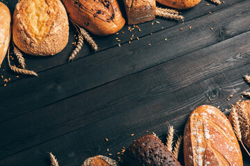 Bread border on wood background with copy space.Different types of bread arranged as frame with...