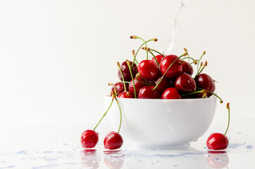 bowl full of sweet cherries on white background