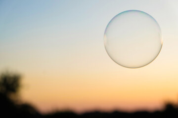 Blurred sunset sky background with soap bubble