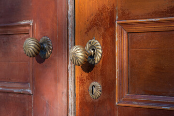 Antique copper ornate an aged wooden door.