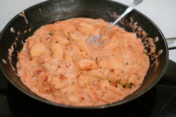 People making meat sauce together. Frying pan with sauce on an induction stove. Concept of home...