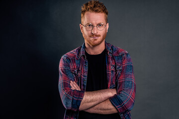 Let us get to business. Portrait of good-looking confident redhead mature guy with bristle in round glasses, holding hands on chest and smiling broadly, looking after employees in office