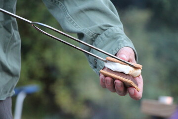 Man holding a smore while camping