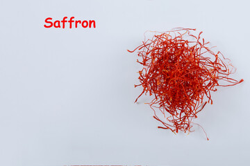 Naklejka premium Saffron threads on a white background with the inscription Saffron. Copy space.