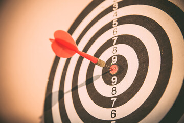 Bullseye or dart board has dart arrow throw hitting the center of a shooting target for business...