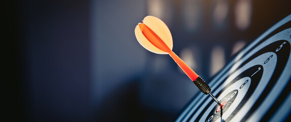 Bullseye or dart board has dart arrow throw hitting the center of a shooting target for business...