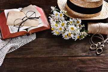 rustic style flat lay with daisy flowers and old book on wooden table