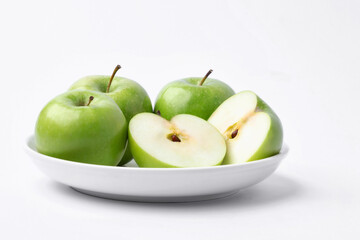 Fresh green apples in a dish on white background