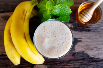 Banana fresh cocktail vanilla smoothies  fruit juice beverage healthy the taste yummy in glass drink episode good morning on wooden background from the top view.