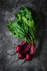 Red Beetroot with herbage green leaves on stone background