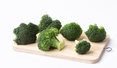 fresh broccoli on wooden cutting board on white background.