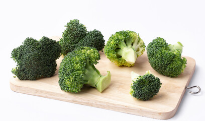 fresh broccoli on wooden cutting board on white background.